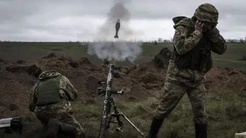 Getty Images Ukrainian soldiers fire a mortar