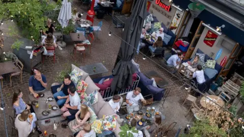 Getty Images An aerial view of customers enjoying al fresco dining and drinking at a bar