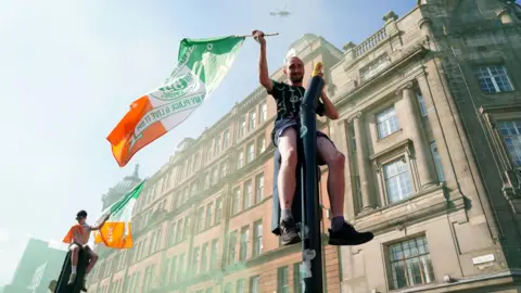 PA Media Fans scaled traffic lights as the police helicopter hovered overhead