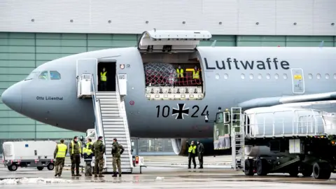 AFP Staff of the German armed forces Bundeswehr stand around an Airbus A310-304 MRTT military transport plane of German armed forces Bundeswehr at the military airport in Wunstorf near Hanover, northwestern Germany, on February 3, 2021