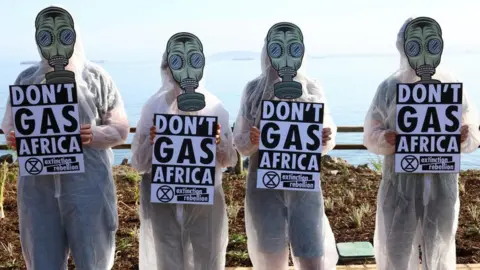 Reuters Climate activists from Extinction Rebellion hold placards outside the Africa Energy Week Conference