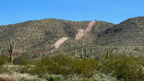 Laiken Jordahl/Center for Biological Diversity Construction on Monument Hill above saguaro cacti