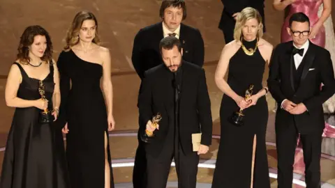 Reuters Mstyslav Chernov (centres) and his Oscar-winning team in Los Angeles. Photo: 10 March 2024