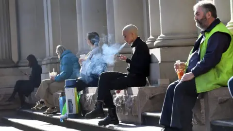 AFP Workers sit socially distanced from each other outdoors on a lunch break in Melbourne's city centre on 19 June