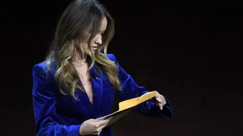 Getty Images Olivia Wilde opening the letter while on stage in a theatre in Las Vegas on Tuesday