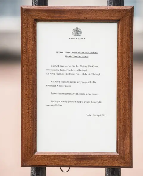 PA Media A notice announcing Prince Philip's death attached to the gates at Buckingham Palace