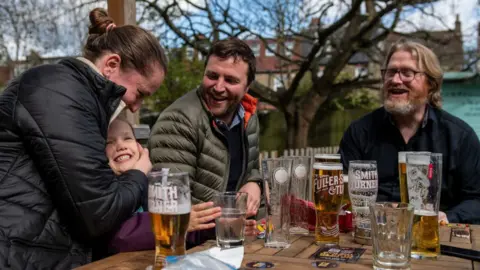 Getty Images A group of people sitting at a pub garden table