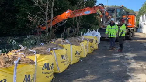 Large sand bags along the riverbank