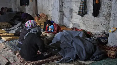 AFP Displaced Syrians who fled the town of Jandaris shelter in the city of Afrin (25 January 2018)