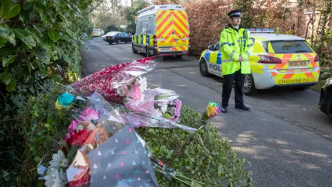 PA Media Floral tributes at the scene