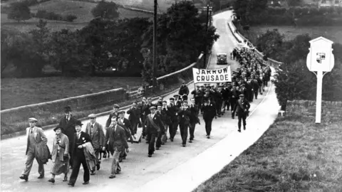 Getty Images Jarrow March of unemployed miners and shipbuilders from north-east England set out on 5 October 1936 to march the 280 miles (451 km) to London to petition Parliament for relief and the creation of jobs