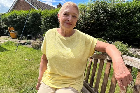 Richard Knights Gillian Mansbridge, from Mattishall, Norfolk, sitting on a bench