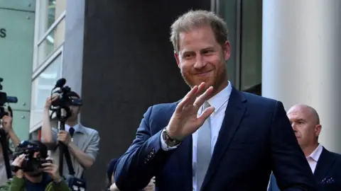 Reuters Prince Harry smiling and waving outside London's High Court.