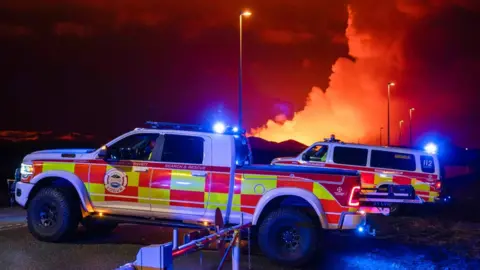 Getty Images Emergency vehicles are seen as molten lava flows out from a fissure on the Reykjanes peninsula