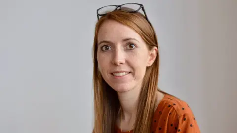 Sarah Sloane Photography Photo of Victoria Hatton. She is wearing an orange spotted top and glasses.