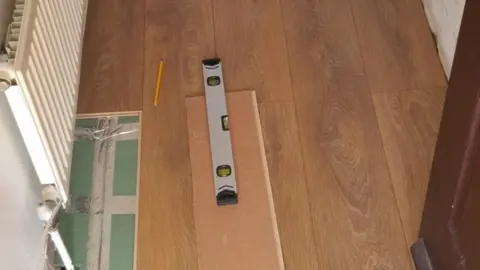 Alex Wright The laminate floor.