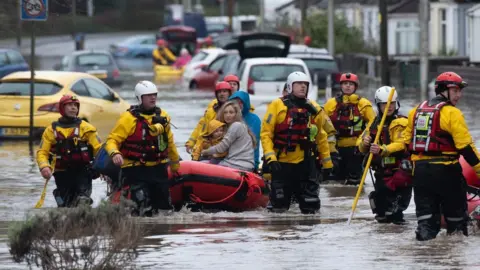 Getty Images A family is rescued from floodwater in Nantgarw by boat