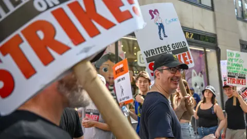 Getty Images John Oliver joins Writers Guild of America East (WGA) to walk the picket line on day 87 during a ‘comedy writers rally’ outside of NBC Rockefeller Center on July 27, 2023 in New York City.