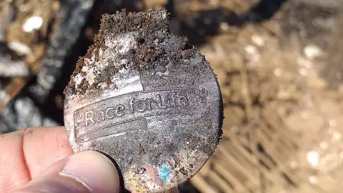 Skylarks Experimental Archaeology Race for life medal found in ashes