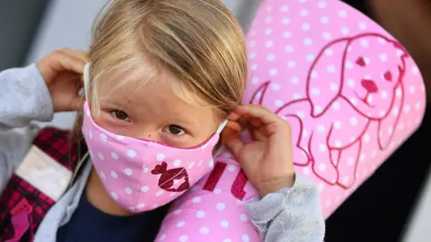 Reuters A six-year-old schoolgirl on her way to school in a facemask in Germany