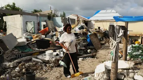 Getty Images Flo Webber stands amongst the debris of her home on the nearly destroyed island of Barbuda which was nearly levelled when Hurricane Irma made landfall with 185mph winds.