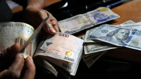 AFP A man exchanges Nigerian naira for US dollars in Lagos, Nigeria - 2021