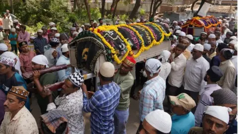 EPA People carry the bodies of some of the victims of a suspension bridge collapse, during a funeral procession in Morbi, Gujarat state, India, 31 October 2022.