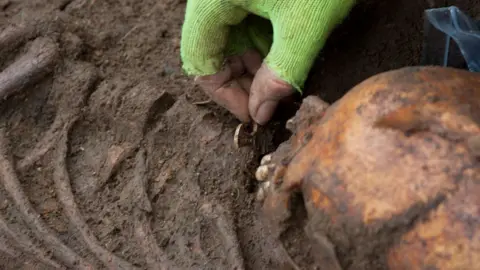 University of Cambridge Archaeological Unit Discovery of cross on 7th Century woman's skeleton, Trumpington