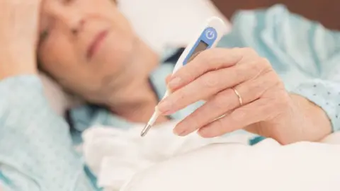 Getty Images Woman in bed with flu
