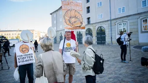 Getty Images Demonstrators hold up posters in support of former Danish Immigration Minister Inger Stoejberg