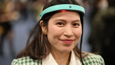 Getty Images A person wearing a blue, rigid electronic headband with a light showing underneath it