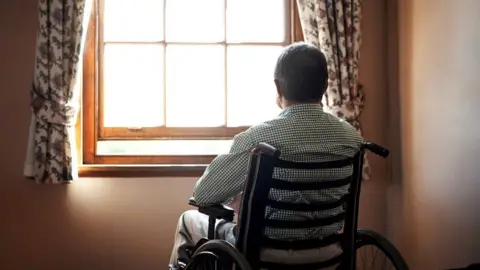 Getty Images Man looking out of window