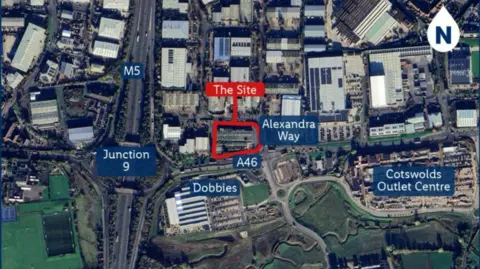 The image is an aerial map view of a commercial and industrial area. The proposed Lidl site is highlighted in red. "Alexandra Way", "A46", and "Junction 9" on the M5 motorway are labelled in blue, showing major roads and access points.
Nearby landmarks: "Dobbies" and "Cotswolds Outlet Centre" are also labelled in blue.