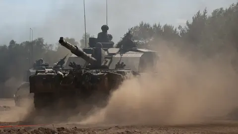 Reuters British Army soldiers from Badger Squadron, The Royal Tank Regiment part of the 12th Armoured Brigade Combat Team ride a Challenger 2 tank during Exercise Immediate Response as one component of NATO’s Exercise Steadfast Defender 2024, in Drawsko Pomorskie training area, Poland May 15, 2024