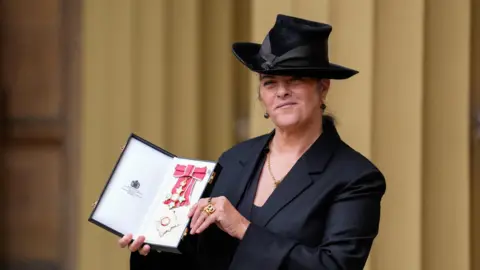 Reuters Artist Dame Tracey Emin poses for a photograph  aft  being made a Dame Commander astatine  an Investiture ceremonial  astatine  Buckingham Palace