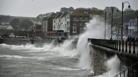 PA Waves crashing against the harbour wall in Penzance, Cornwall