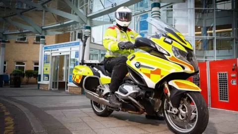 Whiteknights Yorkshire Blood Bikes Rider on blood bike outside a hospital A&E department