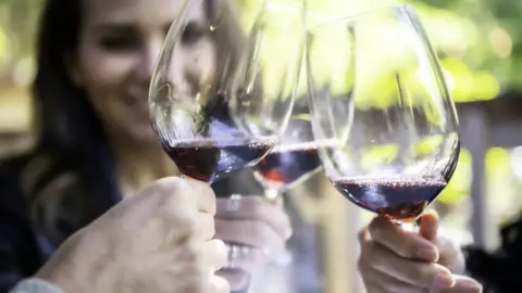 Getty Images Woman drinking with friends