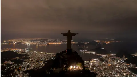 Getty Images The statue of Christ the Redeemer is seen after being plunged into darkness for the Earth Hour environmental campaign on top of Corcovado hill in Rio de Janeiro, Brazil, on March 26, 2022.