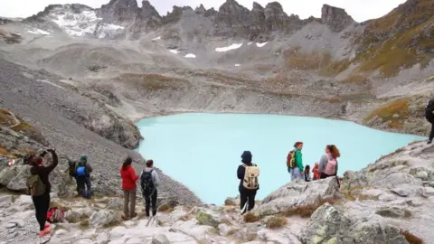 Getty Images People look at the Pizol glacier as they take part in a mourning ceremony