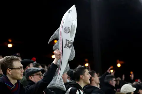 Getty Images Grimsby Town supporters brandishing an inflatable fish