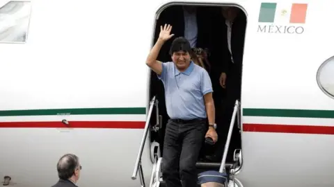 Reuters Evo Morales waves during his arrival to take asylum in Mexico, in Mexico City, Mexico, November 12, 2019