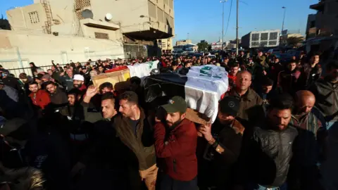 Getty Images Crowds attend funeral ceremonies of those who lost their lives during twin suicide bombing attack at al-Tayaran Square in Baghdad, Iraq on January 21, 2021
