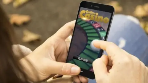 Getty Images Mobile phone with gambling site