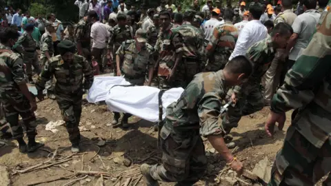 AFP Indian army soldiers and rescue personnel look for survivors after a landslide along a highway at Kotrupi