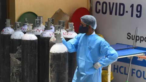 Getty Images A health worker moving an oxygen cylinder at the Covid-19 Care Centre set up at Shehnai Banquet Hall attached to LNJP Hospital, on May 8, 2021 in New Delhi, India.