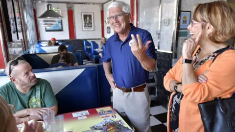 Getty Images Image shows Chuck Morse (centre) speaking with voters