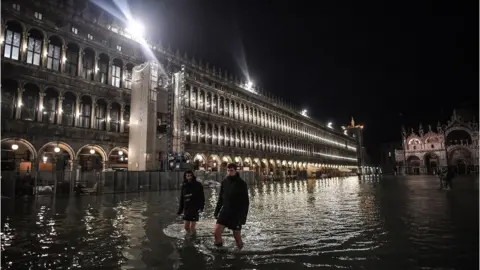 AFP People wade through water in St Mark's Square