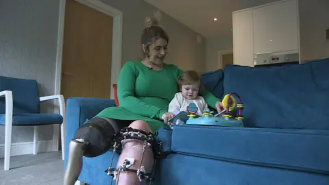 BBC Medical gaming patient Ruby Flanagan sits on a sofa with son Leon