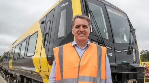 Liverpool City Region Steve Rotheram in front of one of the new trains